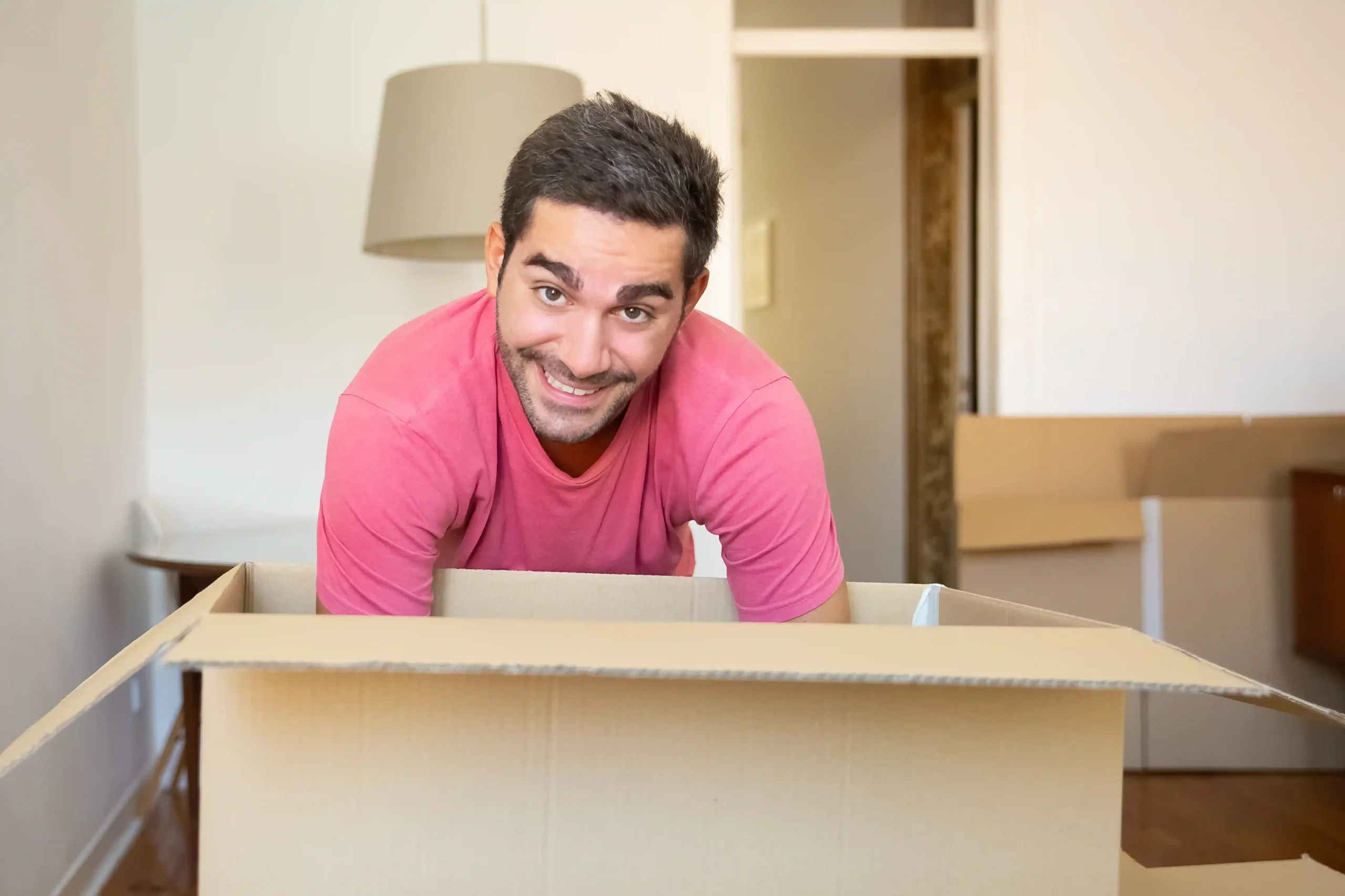Young man unpacking items at this new room